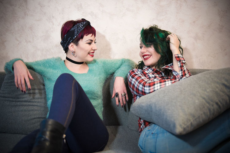 Two young women laughing on sofa