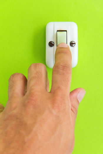 Cropped hand of man touching switch