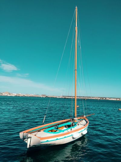 Sailboat sailing on sea against blue sky