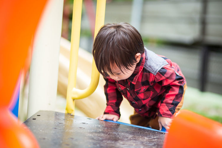 Boy playing on slide at playground