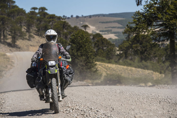 Woman on touring motorbikes driving on gravel road in argentina