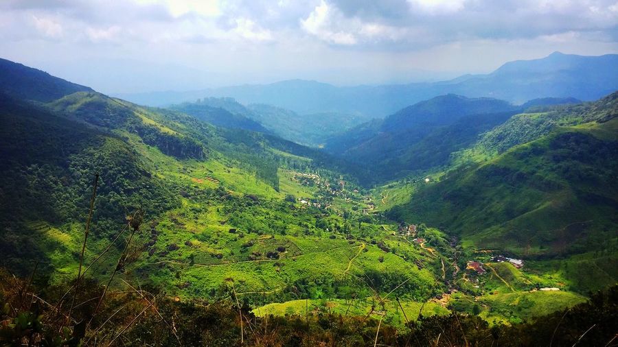 Scenic view of mountain range against cloudy sky