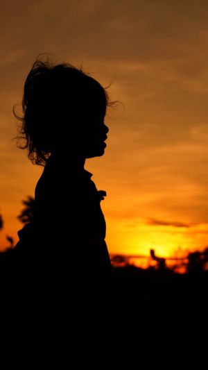 Portrait of silhouette woman against orange sky