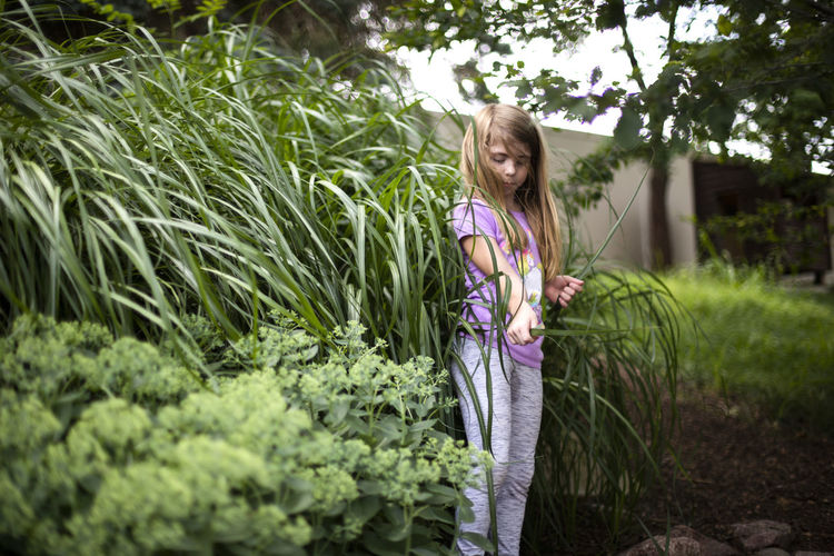 Girl standing against plants