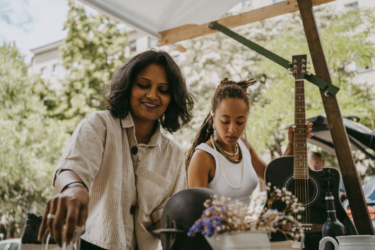 Female partners arranging products at flea market