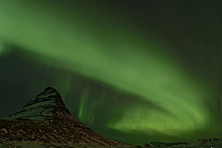 Low angle view of aurora borealis at night during winter