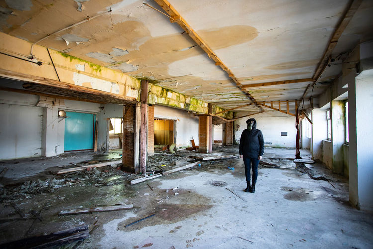 Full length of woman standing in abandoned building