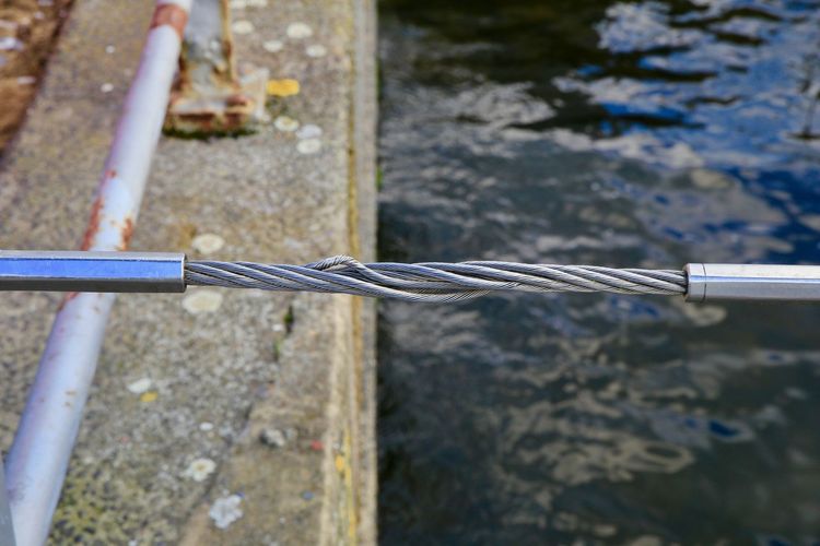 Close-up of metal rope tied to metal railing