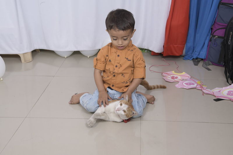 High angle view of boy sitting on floor at home