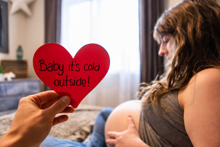 Midsection of woman holding heart shape with text