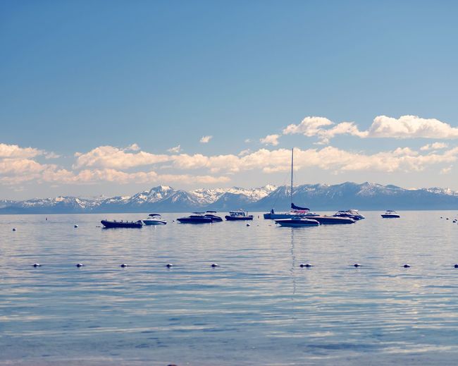Boats sailing in sea against sky