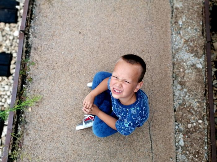 High angle view of boy sitting outdoors