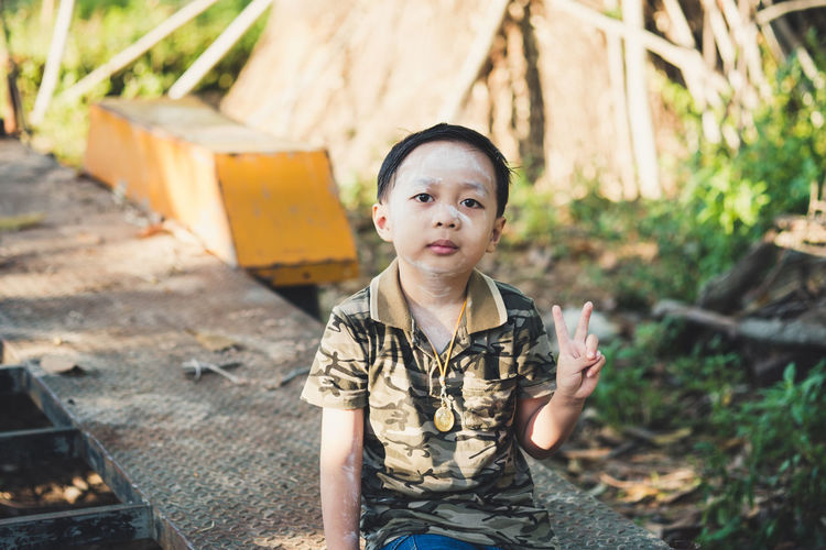 Portrait of boy showing peace sign