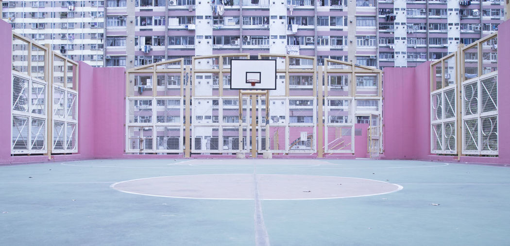 Empty basketball court against buildings in city