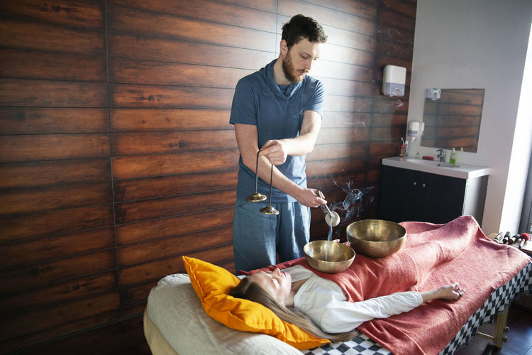 Young man preparing food on bed