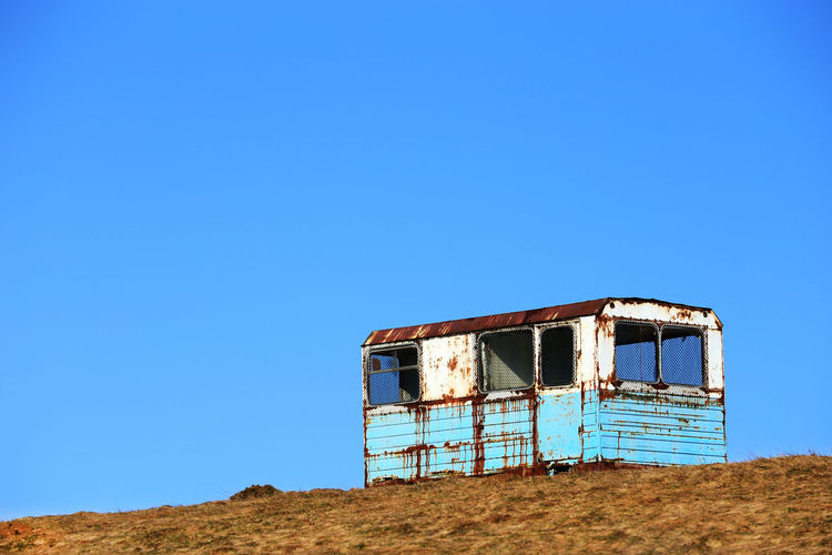 Abandoned cabin against clear blue sky