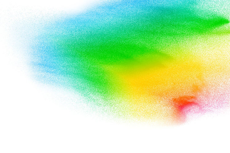 Defocused image of multi colored powder paints against white background