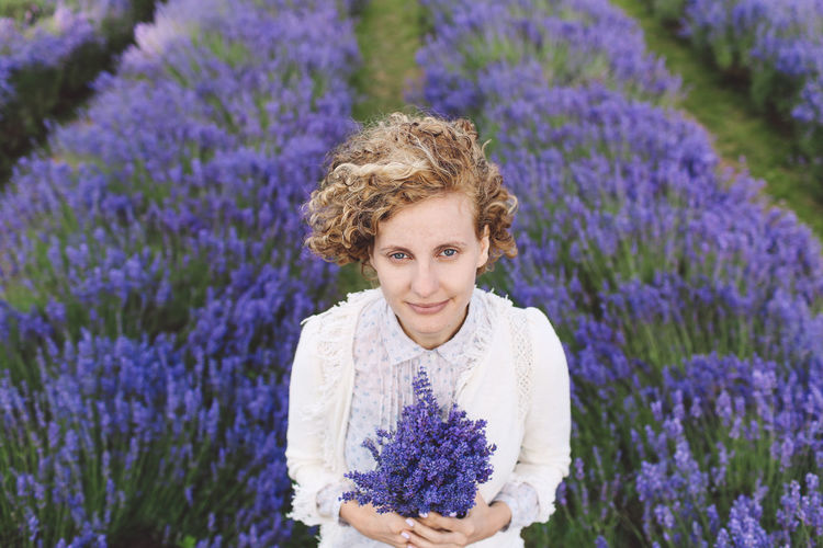 Portrait of woman holding purple flowers