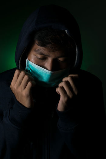 Close-up portrait of a young man covering face