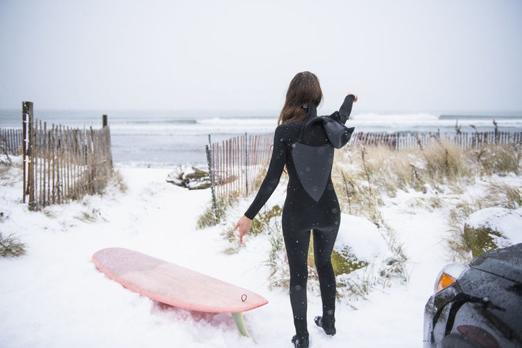 Woman going surfing in winter snow