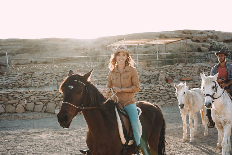 Young people riding bitless horses inside corral - focus on woman face