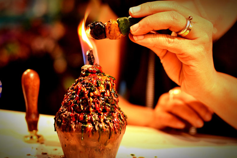 Close-up of hand holding drink on table