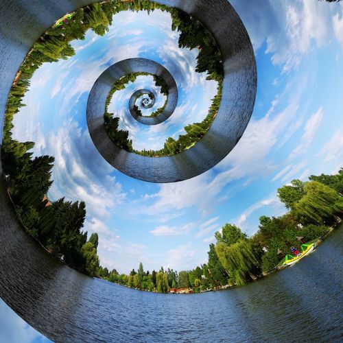 Digital composite image of lake and trees against sky