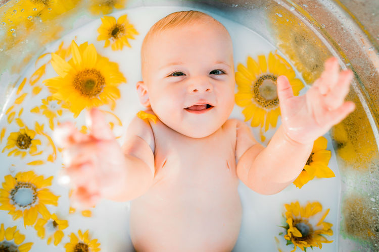 Portrait of cute baby girl with yellow flower
