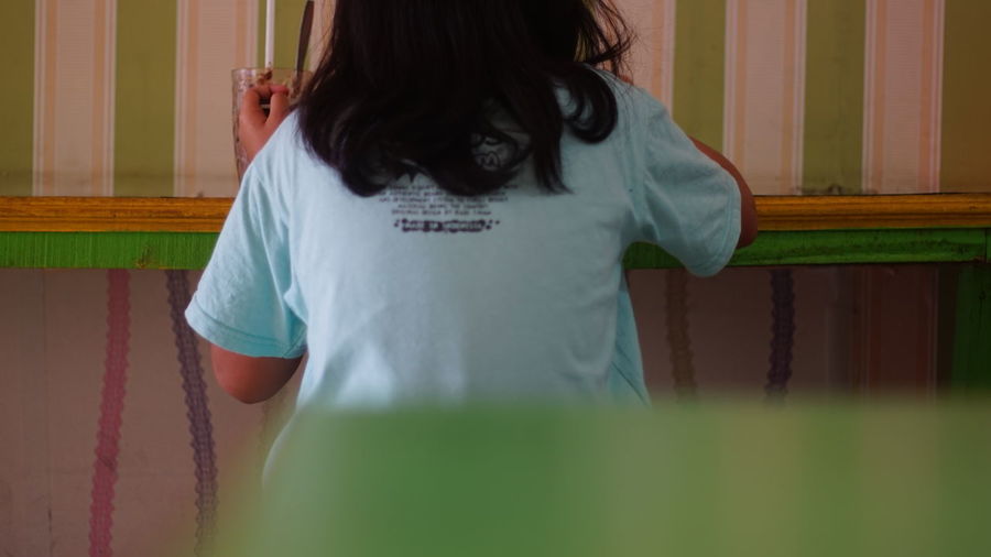 Rear view of woman standing at home