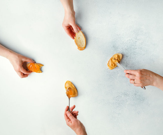 Cropped image of hand holding cookies on table