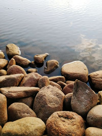 Close-up of pebbles in sea
