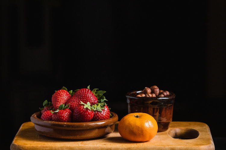 Still life with strawberries, hazelnuts and a tangerine