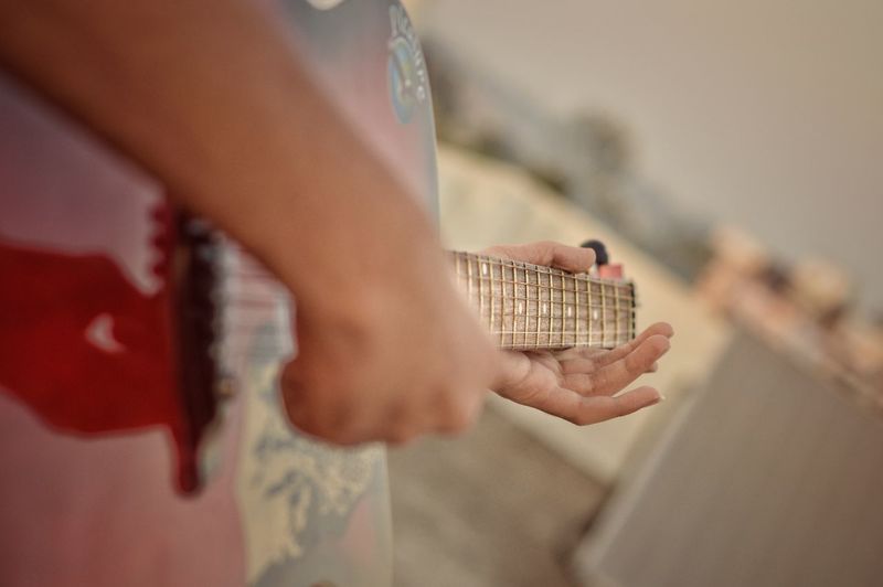Cropped hands playing guitar