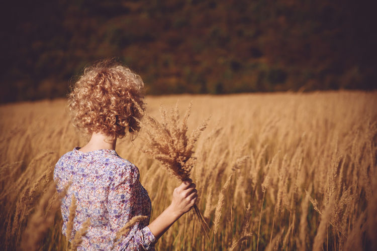 Woman holding plant in field