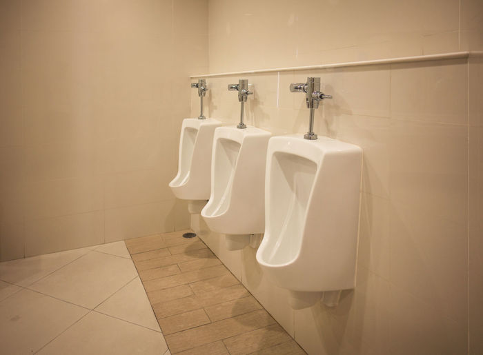 Urinals by wall in bathroom