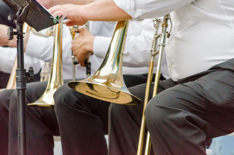 Midsection of men playing trumpets