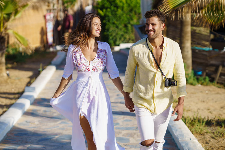Smiling couple holding hands walking outdoors