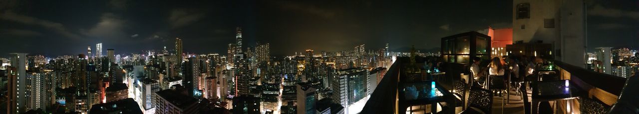 Panoramic shot of illuminated buildings against sky at night