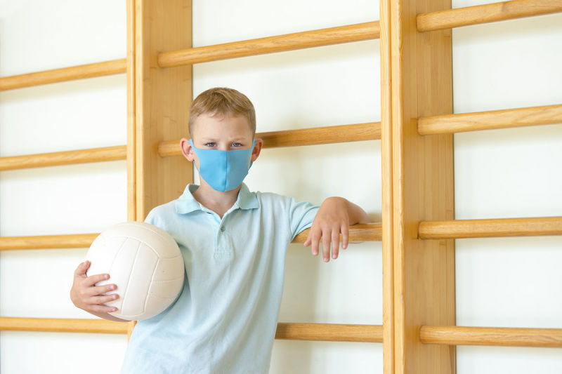 Full length of boy standing against wall