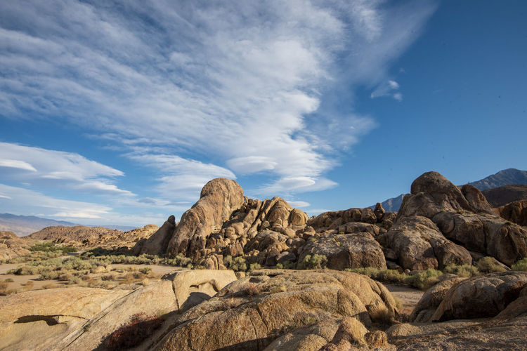 Scenic view of rock formations against sky in desert landscape with cloud formations above