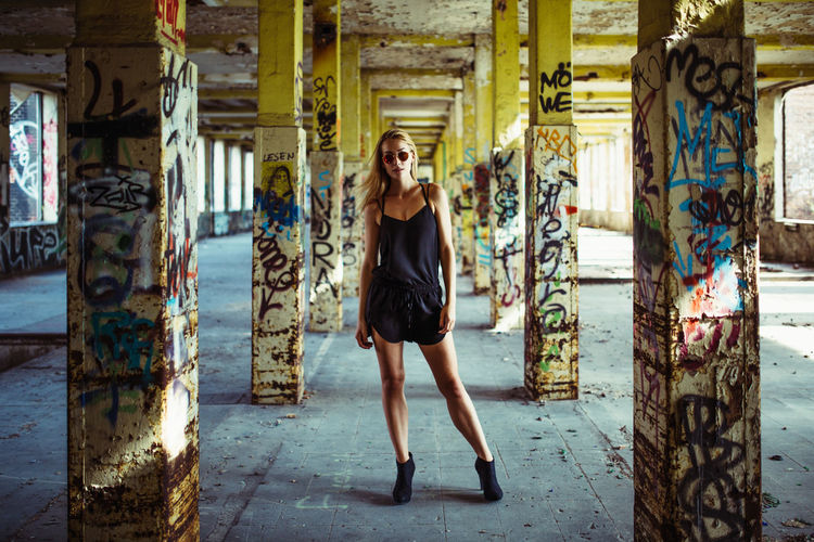 Portrait of young woman in abandoned, graffitied buidling