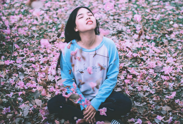 Woman relaxing on petals at park