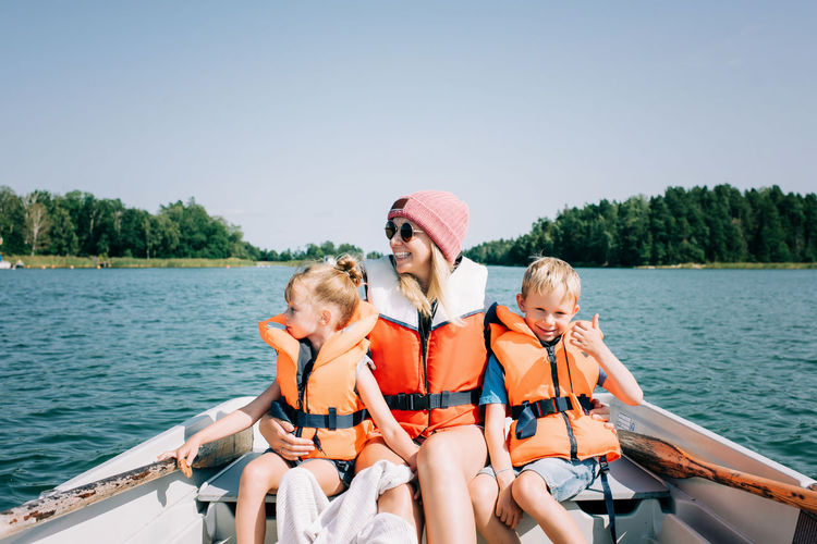 Mother sat happily with her kids on a boat enjoying summer in sweden