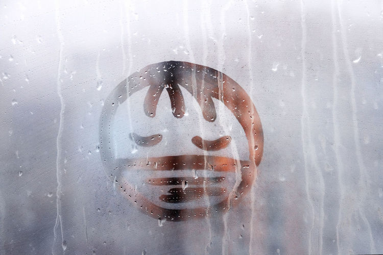 View of anthropomorphic smiley face on wet glass