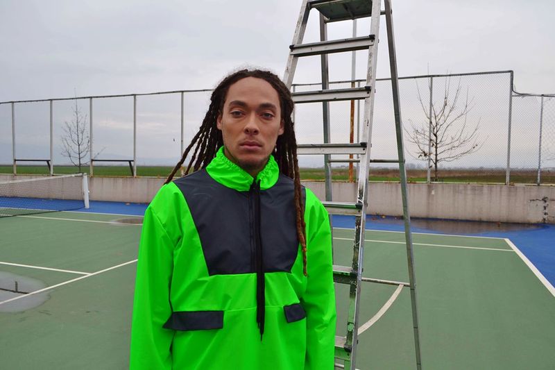 Portrait of man standing by ladder at sports court