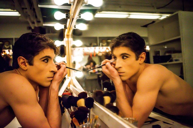 Young man applying stage make-up