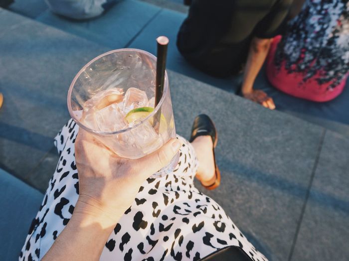 Low section of woman holding drink