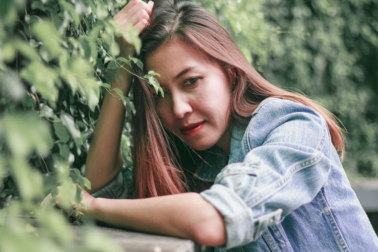 Portrait of beautiful young woman in plant