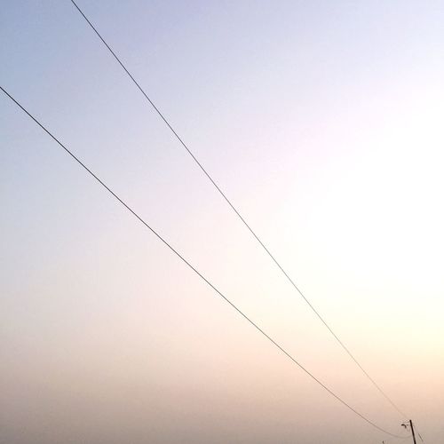 Low angle view of cables against sky during sunset