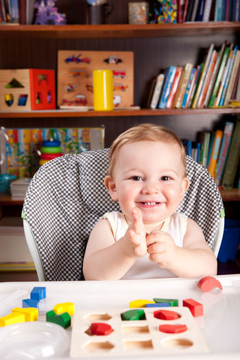 Portrait of cute baby boy playing with toy blocks on table